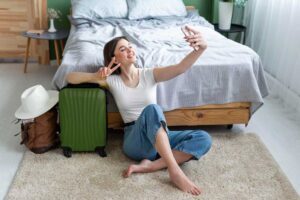Woman taking a selfie in a hotel room. accommodation safety while traveling solo is a priority.